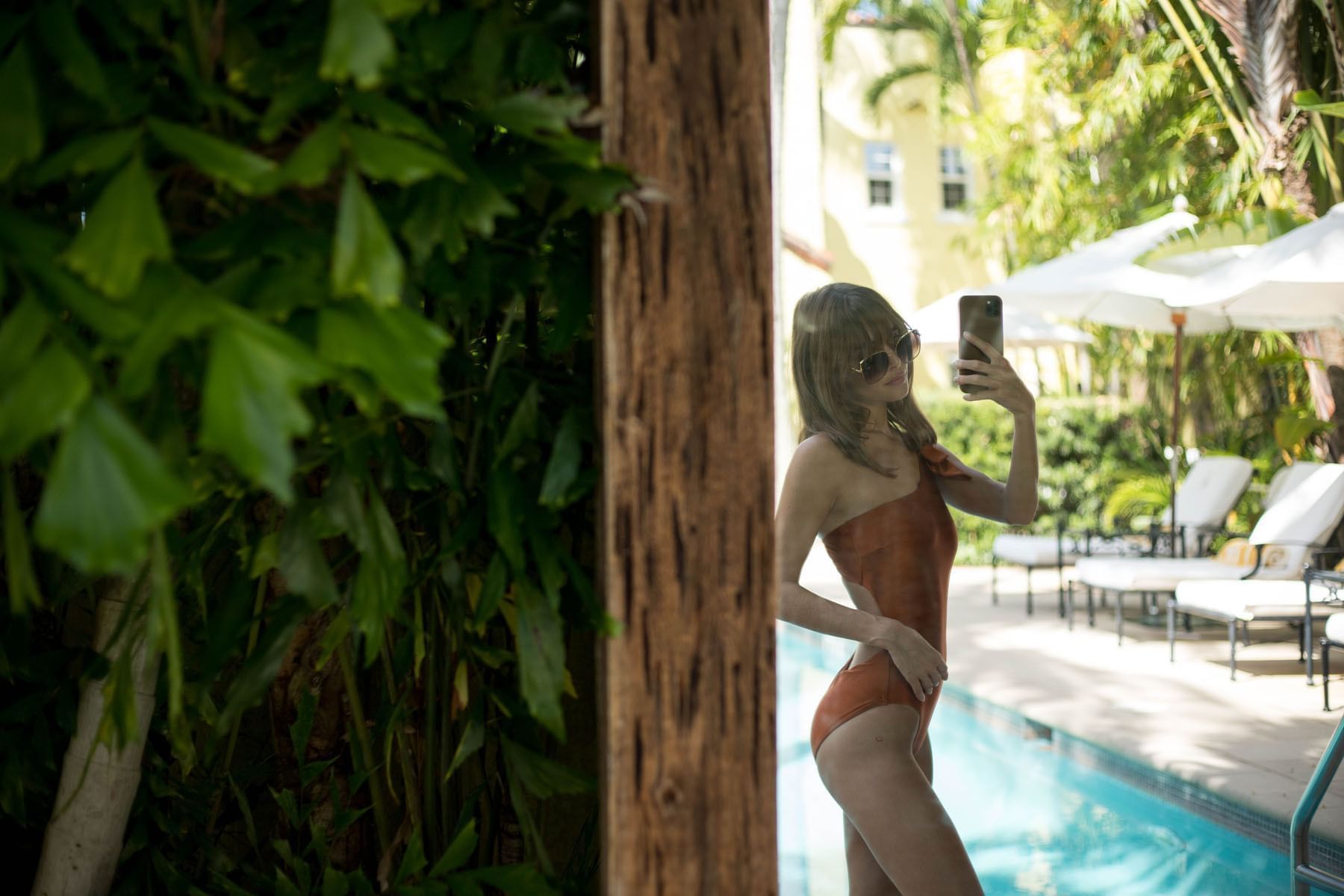A girl taking mirror selfie near the pool at Brazilian Court