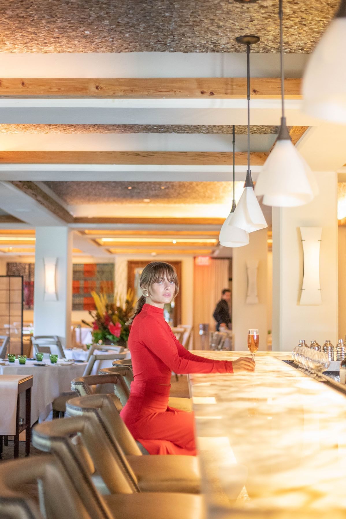 A woman having cocktail in Boulud Bar at Brazilian Court